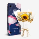 Sunflower bouquet with chocolates, wrapped in paper and tied with ribbon, next to a decorative box.