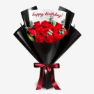 Bouquet of 12 red roses in black wrapper with "Happy Birthday!" card and red ribbon.