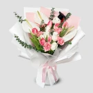 Bouquet of white anthuriums, pink and white tulips, pink carnations, and eucalyptus with a graduation charm.