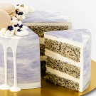 Earl Grey Lavender Cake with white frosting, macarons, and edible flowers.