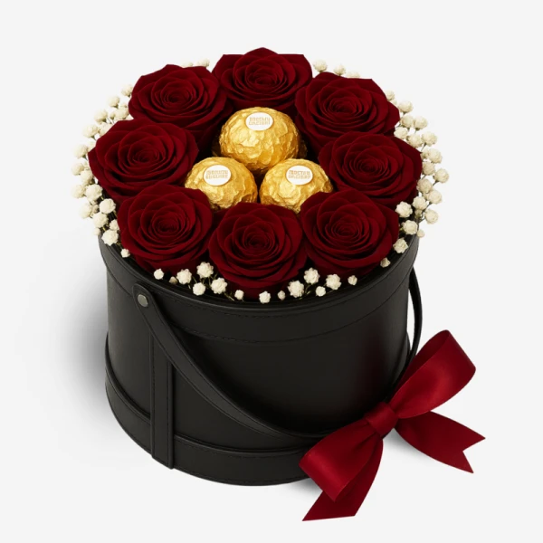 Round black box with preserved red roses and Ferrero Rocher chocolates, tied with a red ribbon.
