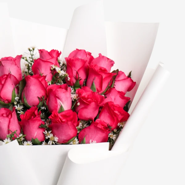 A bouquet of 18 vibrant pink roses with white accents, beautifully wrapped in white paper.