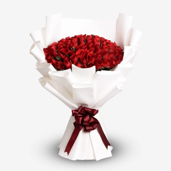 A large bouquet of 99 vibrant red roses, expertly arranged and wrapped in white paper, tied with a deep red ribbon.