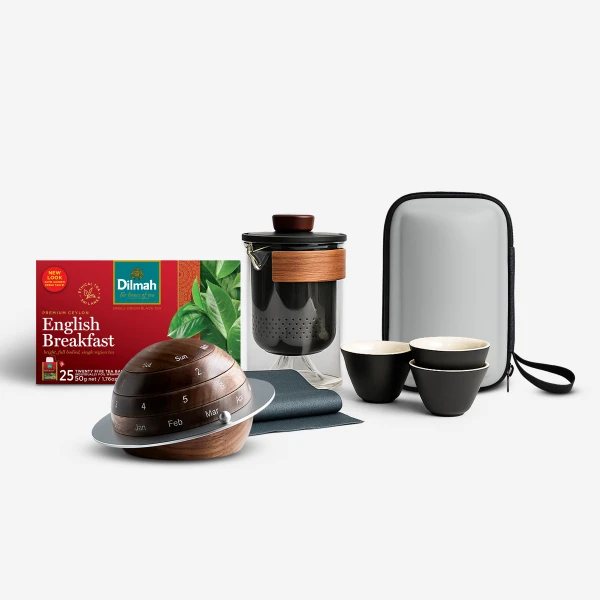 Tea set with teapot, cups, and Dilmah English Breakfast tea box on a white background.