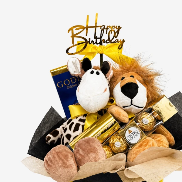 Birthday gift box with plush lion and giraffe, Godiva chocolate, Ferrero Rocher, and "Happy Birthday" cake topper.