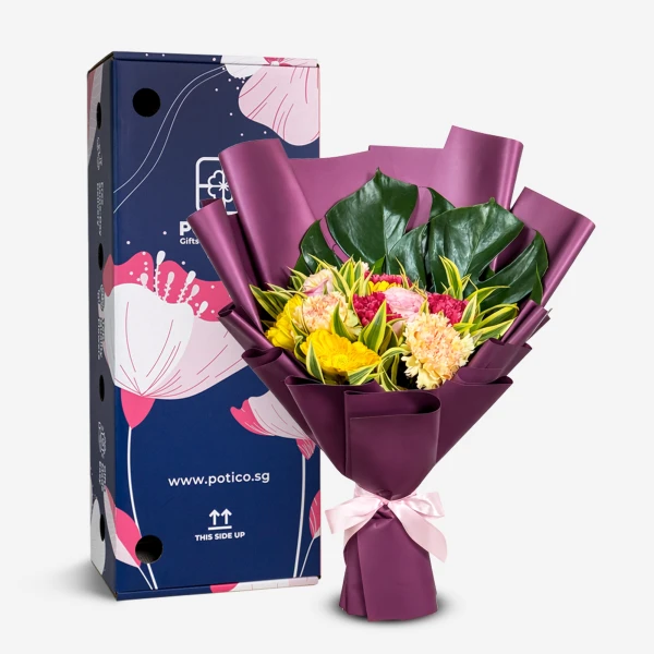 A flower bouquet with yellow, pink, and fuchsia blooms, wrapped in purple paper, next to a blue gift box.