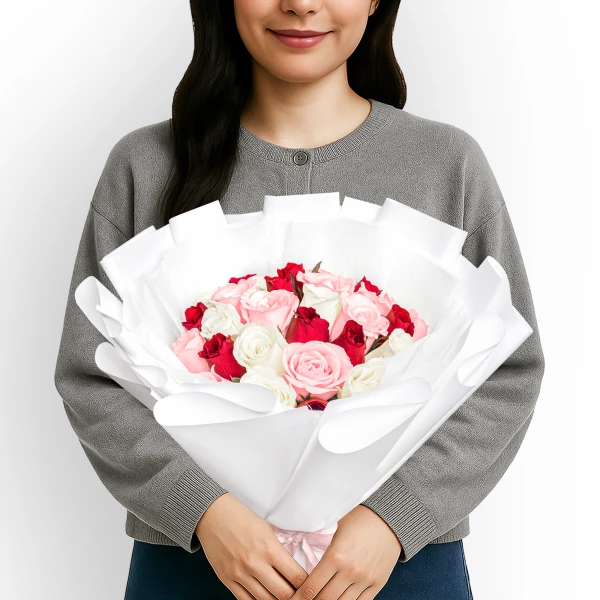 A person holding a bouquet of 30 red, pink, and white roses.