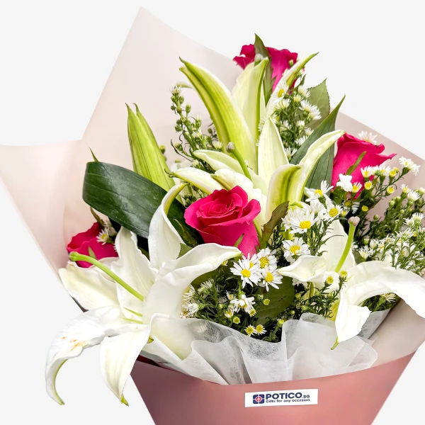 A bouquet of white lilies and pink roses with small white flowers, artfully arranged and wrapped.