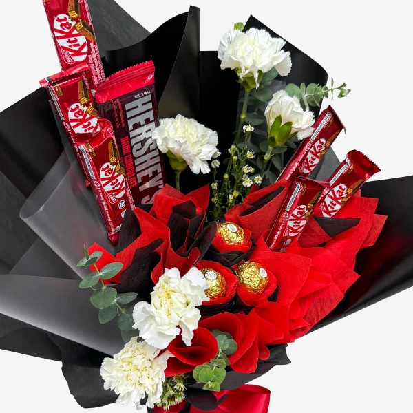 Chocolate bouquet with Kit Kats, Hershey's, Ferrero Rocher, and white carnations.