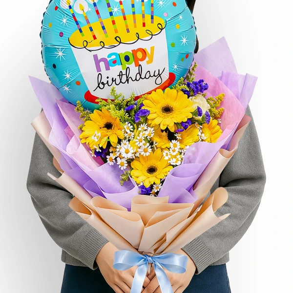 A bouquet of yellow gerbera daisies and white daisies with a blue happy birthday balloon.