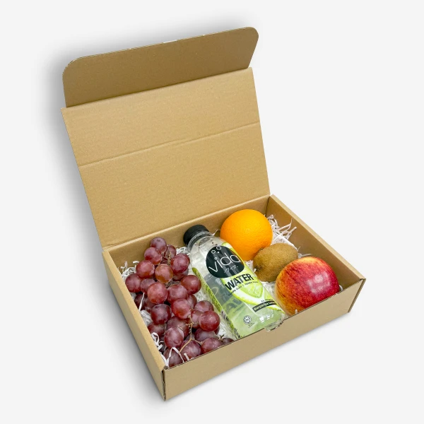 Cardboard gift box with grapes, orange, kiwi, red apple, and bottle of Vida lime water.