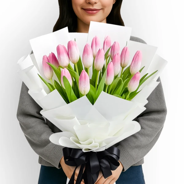 A bouquet of 20 pink tulips wrapped in white paper and tied with a black ribbon.
