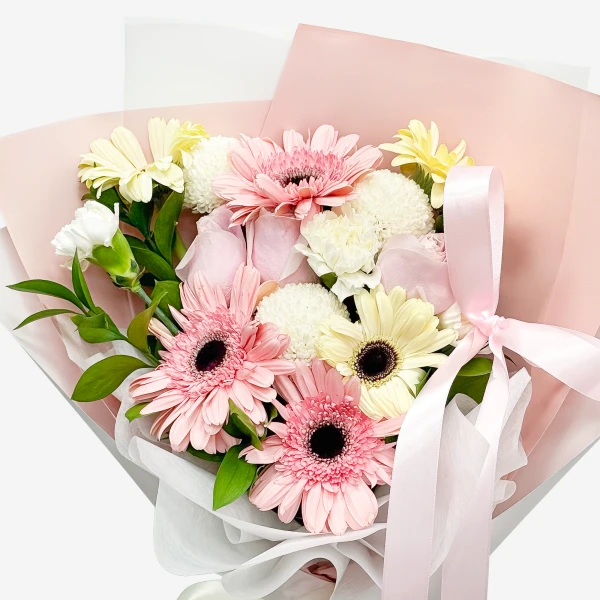 A bouquet of pink and white gerbera daisies and carnations with a pink ribbon.