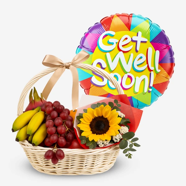 Wicker basket with bananas, grapes, dragon fruit, sunflower bouquet, and "Get Well Soon!" balloon.