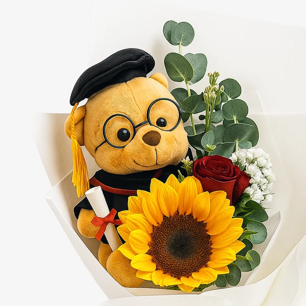 Graduation teddy bear with sunflower, rose, and eucalyptus in a bouquet.