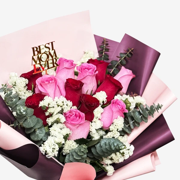 Bouquet of pink and red roses with "Best Mom Ever" topper and eucalyptus, wrapped in pink and purple paper.