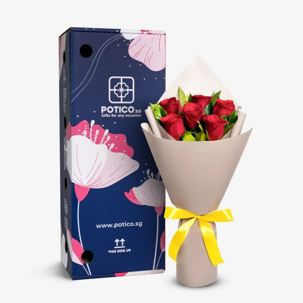 A bouquet of 6 red roses wrapped in neutral paper with a yellow ribbon, next to a blue gift box with floral designs.