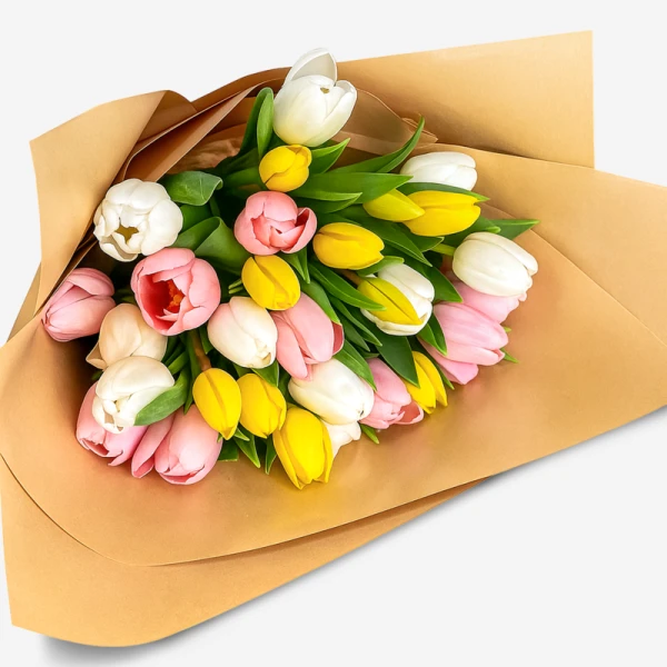 A bouquet of 30 assorted pink, white, and yellow tulips wrapped in brown paper.