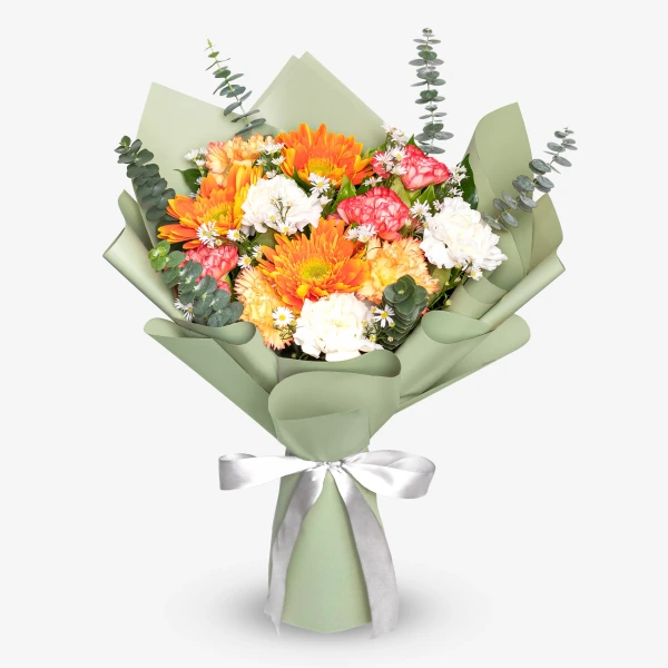 A bright bouquet of orange gerberas, carnations, and white flowers wrapped in green paper with a white ribbon.