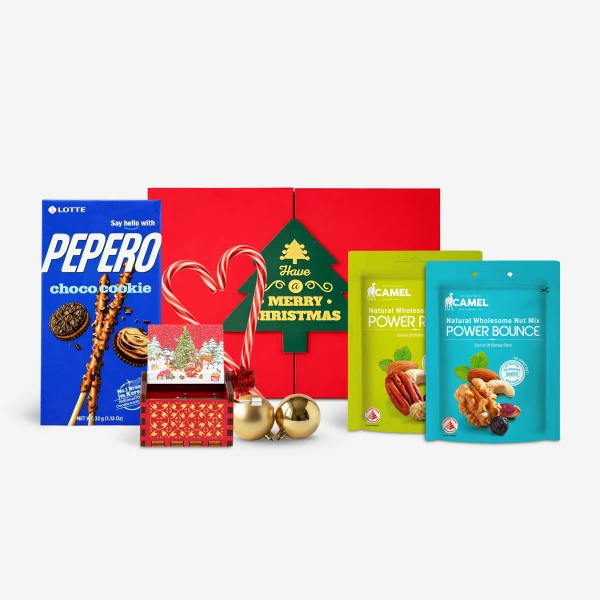 Christmas gift set with Pepero, nuts, candy canes, and ornaments on a red box.