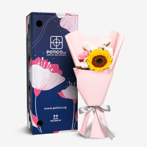 Sunflower and pink carnation bouquet in pink paper with a silver ribbon, next to a navy blue gift box.