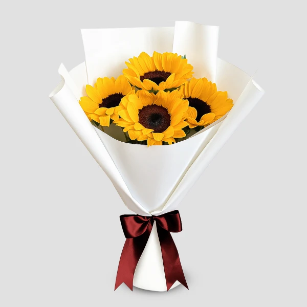 Bouquet of 4 sunflowers with dark centers, wrapped in white paper and tied with a maroon ribbon.