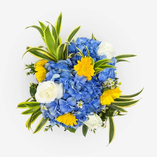 Blue and yellow flowers, white roses, and green foliage arranged in a bouquet against a white background.