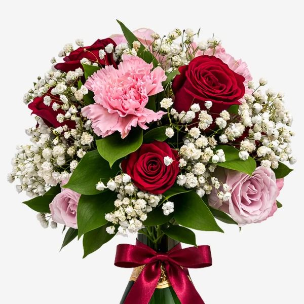 A bouquet of red roses, pink carnations, and baby's breath tied with a burgundy ribbon, with the neck of a green bottle visible.