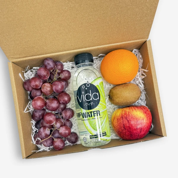 A gift box containing grapes, orange, kiwi, apple, and a bottle of Vida lime water.