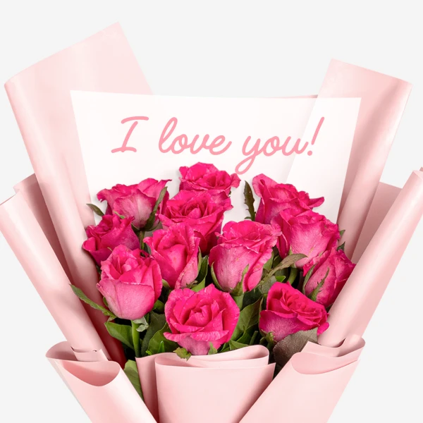 Bouquet of 12 pink roses with a card that says "I love you!".
