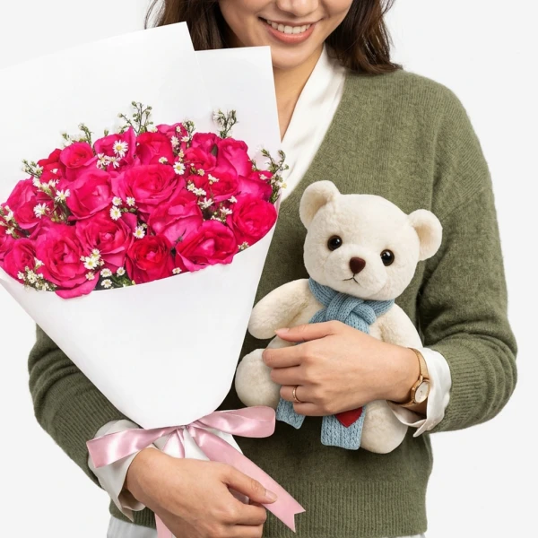 Woman in green sweater holding pink roses bouquet and white teddy bear with blue scarf.