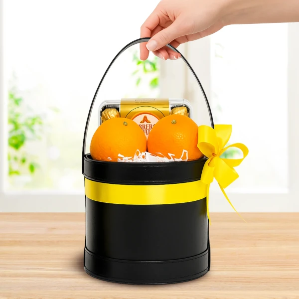 Gift basket with oranges, Ferrero Rocher chocolates, and yellow ribbon.