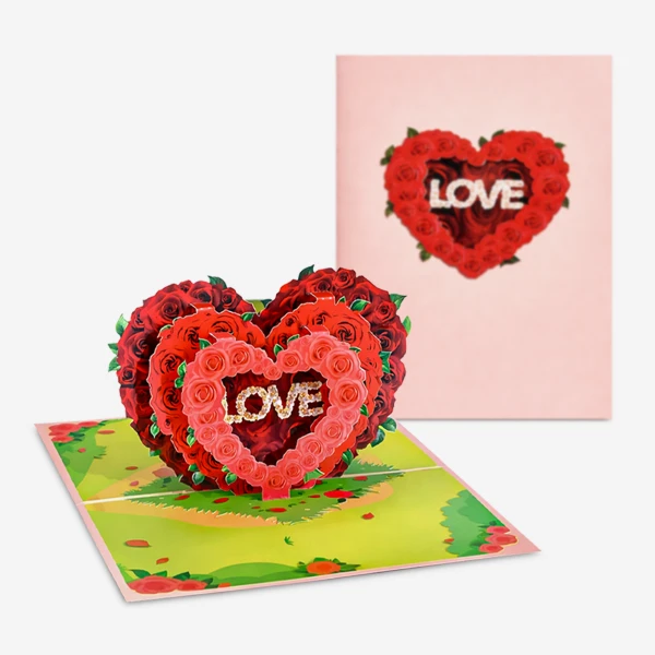 Pop-up heart card with red roses and the word "LOVE" inside, on a green, grassy background.