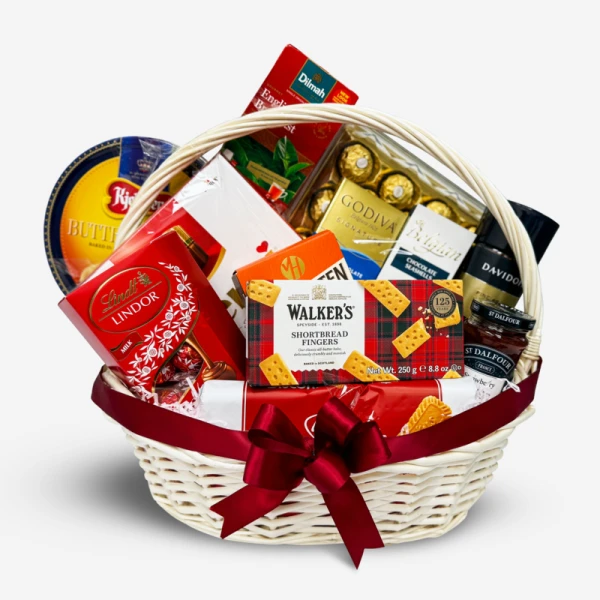Gift basket filled with chocolates, biscuits, and jam, tied with a red ribbon.