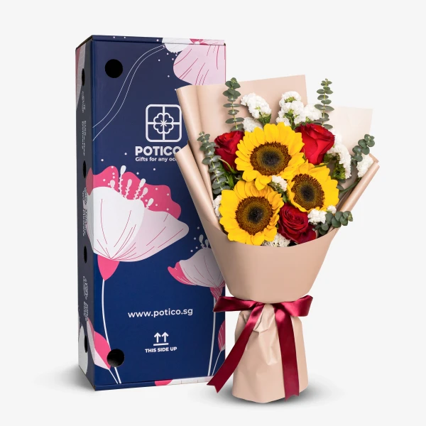 Bouquet of sunflowers, red roses, and eucalyptus in tan paper with a red ribbon, next to a blue box.