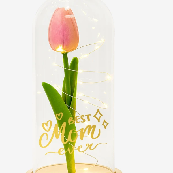 Pink tulip with "Best Mom Ever" inscription under glass dome with fairy lights.