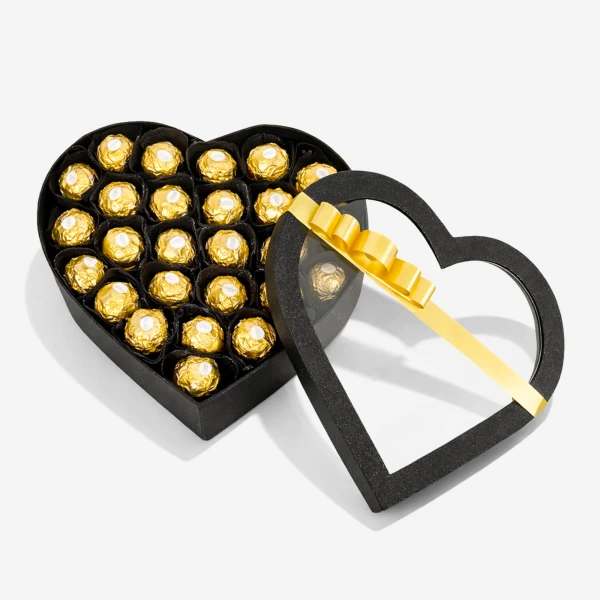 Heart-shaped box filled with golden foil-wrapped chocolates, lid open with a gold ribbon.