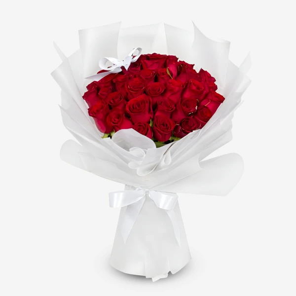 A bouquet of 30 red roses wrapped in white paper, tied with a white ribbon.