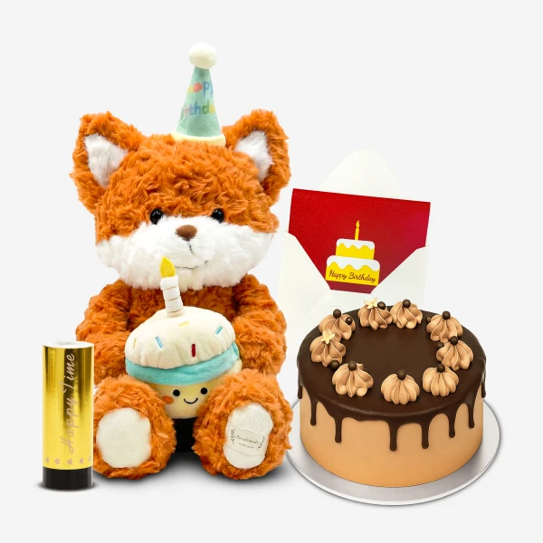 Fox plush with birthday hat holds a cupcake next to a chocolate cake and a birthday card.