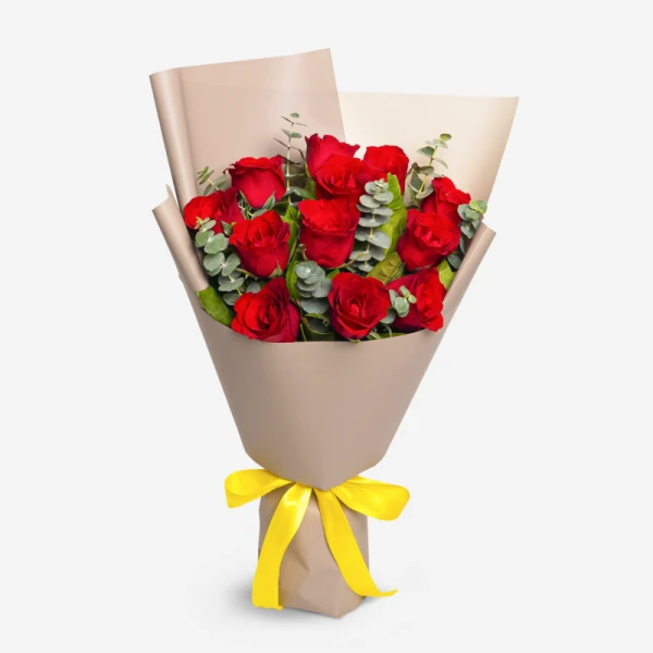 A bouquet of 12 red roses wrapped in brown paper with a yellow ribbon.