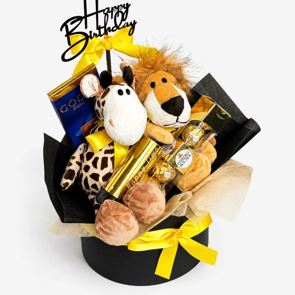 Birthday gift box with giraffe and lion plush toys, chocolates, and a "Happy Birthday" topper.