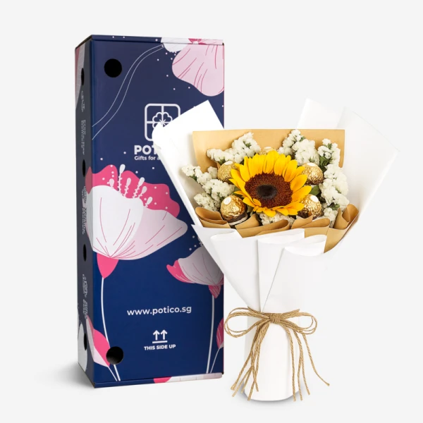 Sunflower, baby's breath, and chocolates in white bouquet next to a blue gift box with pink flowers.