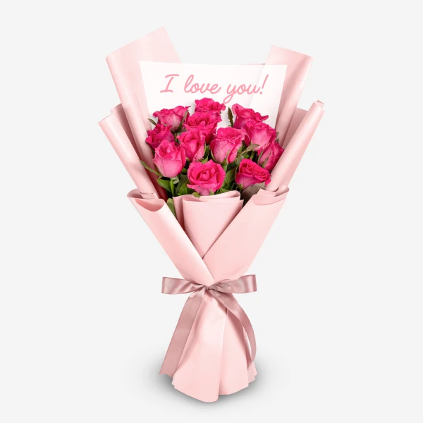 Bouquet of 12 pink roses wrapped in pink paper with a pink ribbon, featuring a card that says "I love you!".