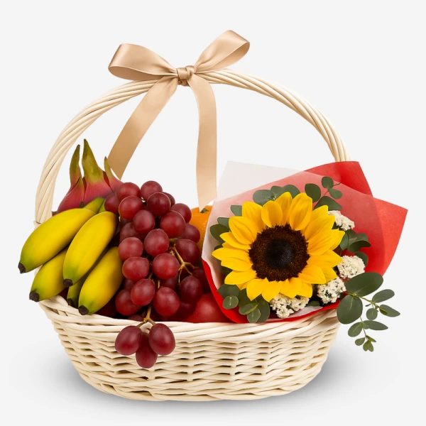 Fruit basket with bananas, grapes, dragonfruit, sunflower, and other fruits, tied with a ribbon.