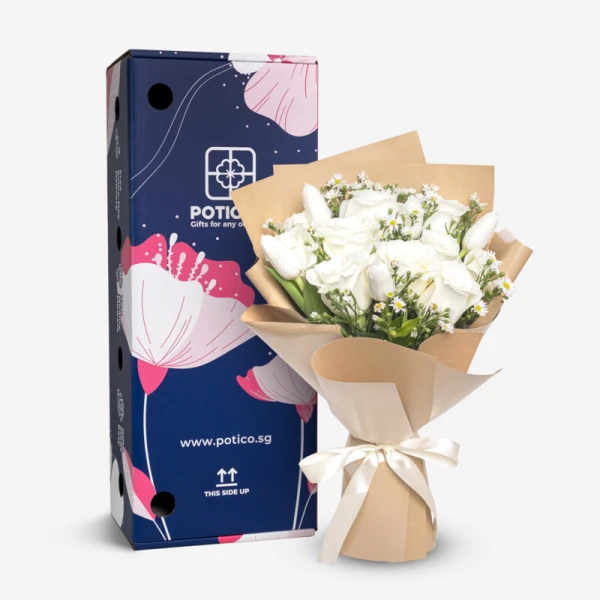 A white rose and tulip bouquet with asters, wrapped in brown paper and tied with a cream ribbon, next to a blue flower-decorated box.