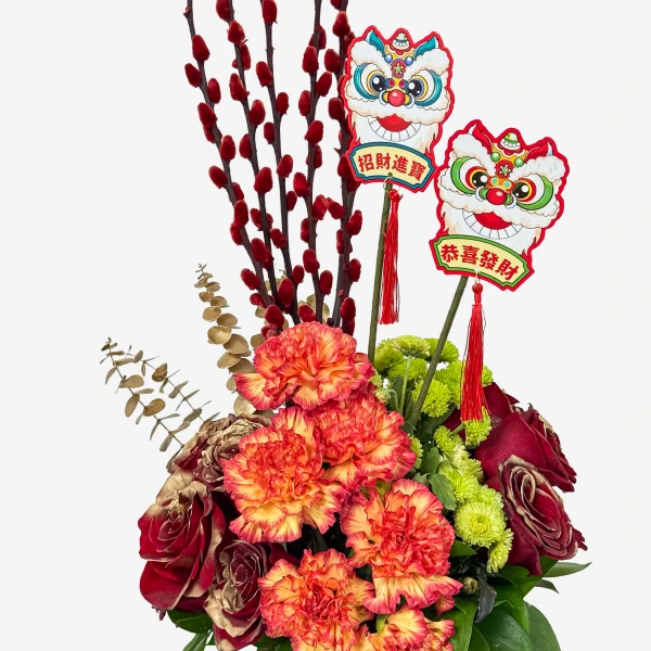 A festive floral arrangement with carnations, roses, red pussy willow branches, and lion dance decorations.