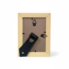 Back of a beige picture frame with stand and hanging hardware.