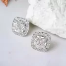 1-Carat cushion-cut moissanite diamond halo stud earrings set in white gold.