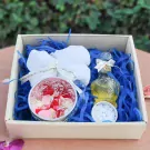 Thai Water Ceremony Set S: A gift box with a white towel, a bowl of flower petals, essence water in a decorative bottle, and white candies.