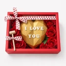 Heart-shaped chocolate piñata with "I love you" written on it, a hammer, and red roses in a red gift box.